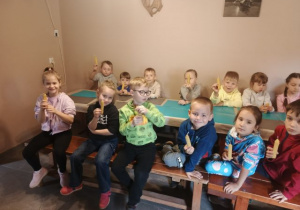 Przedszkolaki prezentują wykonane świece.