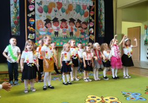 Dzieci podczas występu zakończenia roku szkolnego śpiewają piosenkę.