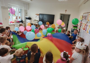 Dzieci podczas zabawy chustą animacyjną i balonami.
