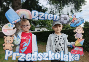 Chłopcy pozują do zdjęcia w fotobudce.