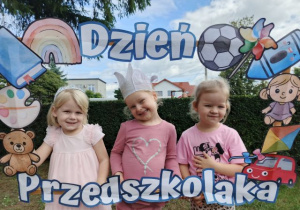 Dziewczynki pozują do zdjęcia w fotobudce.