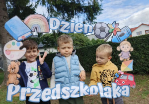Chłopcy pozują do zdjęcia w fotobudce.