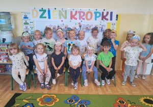 Przedszkolaki pozują do grupowego zdjęcia z okazji Dnia Kropki.