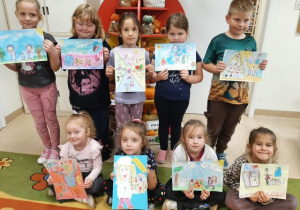 Przedszkolaki prezentują prace plastyczne na konkurs.