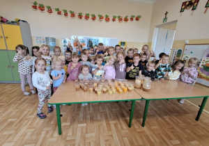 Przedszkolaki pozują do grupowego zdjęcia i prezentują własnoręcznie zrobione soki.