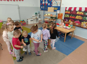 Dzieci ustawione w kolejce odgrywają scenki dramowe