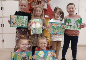 Przedszkolaki prezentują prace na konkurs "Portret Strażaka i Leśnika".