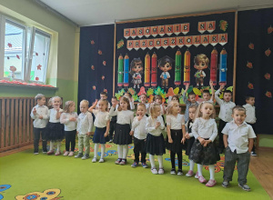 Dzieci dwóch rzędach na tle dekoracji