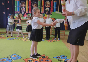 Pani dyrektor pasuje "symbolicznym ołówkiem" dziewczynkę na przedszkolaka