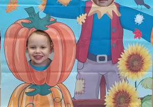 Dzieci w fotobudce z dyniami.