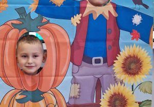 Dzieci w fotobudce z dyniami.