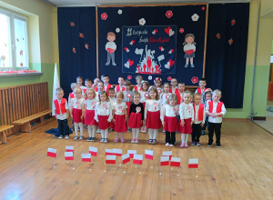 Dzieci na tle dekoracji śpiewają hymn