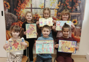 Przedszkolaki prezentują prace na konkurs plastyczny.