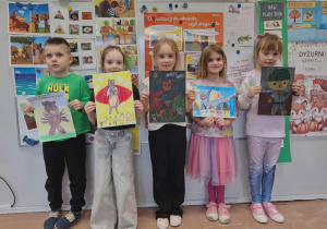 Dzieci stoją z pracami konkursowymi