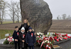 Trójka dzieci z wychowawcą pod Obeliskiem w Starym Gostkowie