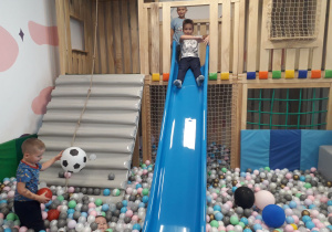 Sala zabaw. Chłopcy bawią się w basenie z piłeczkami.