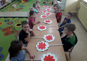 Dzieci przygotowują patriotyczną dekorację- kwiaty.