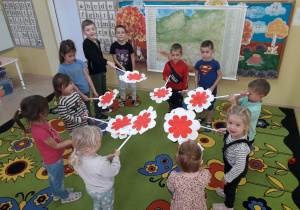 Dzieci prezentują wykonane biało- czerwone kwiaty.