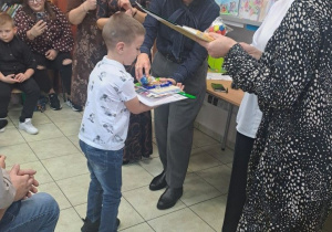 Chłopiec przyjmuje nagrodę za udział w konkursie.