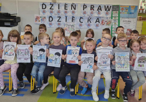 Dzieci w grupie z pokolorowanymi rysunkami