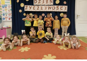 Dzieci z grupy 5,6-latków ubrane na żółto pozują do zdjęcia grupowego.