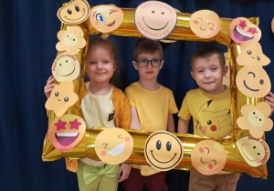 Przedszkolaki pozują do zdjęcia w fotoramce.