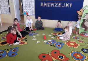 Dzieci na dywanie uczestniczą w andrzejkowej wróżbie: "Co mówią gwiazdy?"