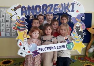 Dzieci pozują do zdjęcia w andrzejkowej fotobudce.