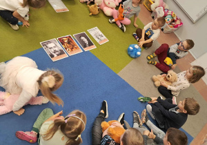 Dzieci siedzą w kole. W środku ilustracje z historią pluszowego misia.