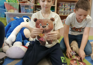 Chłopiec przed sobą łączy części misia.