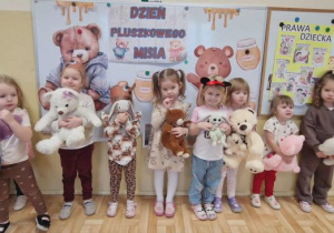 Dziewczynki trzymają swoje misie i pozują do zdjęcia.