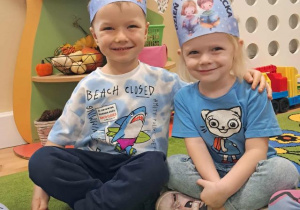 Chłopiec z dziewczynką pozują do zdjęciach, na głowie mają tematyczne niebieskie opaski.