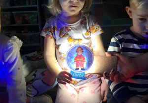 Dziewczynka trzyma obrazek podczas wróżby z zawodami.