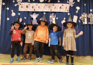 Dzieci w czarnych kapeluszach pozują do zdjęcia.