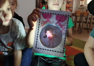 Dziewczynka trzyma obrazek podczas wróżby z zawodami.