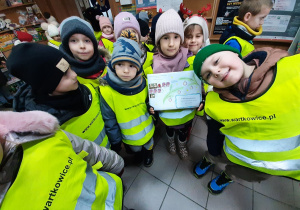 Na poczcie - dziewczynka trzyma list, w otoczeniu kilkoro innych dzieci.