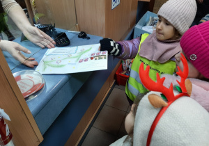 Na Poczcie - dziewczynka przekazuje list do okienka pocztowego