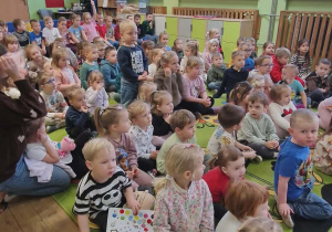 Dzieci siedzą i słuchają muzyków.