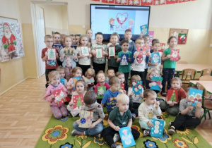 Przedszkolaki prezentują wykonane kartki świąteczne.