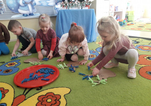 Zabawa matematyczna "Dodawanie z reniferem." Dzieci przypinają na sylwecie renifera spinacze zgodnie z działaniem dodawania.