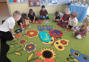 Zabawa matematyczna "Dodawanie z reniferem." Dzieci przypinają na sylwecie renifera spinacze zgodnie z działaniem dodawania.