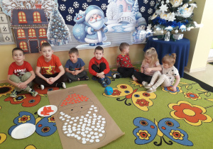 Przedszkolaki prezentują wykonane zadanie matematyczne "Mikołaj."