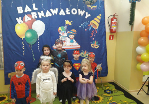 Dzieci w przebraniach karnawałowych pozują do zdjęcia.