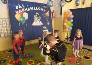 Dzieci w strojach karnawałowych podczas tańca.