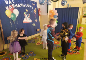 Dzieci w strojach karnawałowych podczas tańca.
