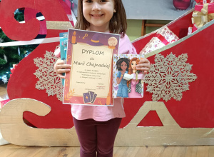 Dziewczynka z dyplomem i nagrodą zdobytą w konkursie