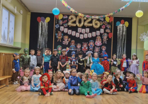 Dzieci w grupie na tle dekoracji.