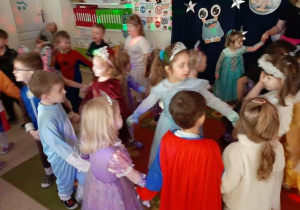 Przedszkolaki tańczą w kole.