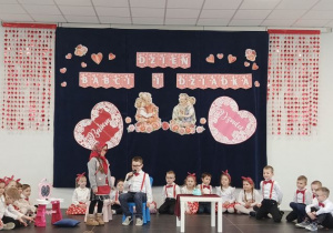 Na scenie dziewczynka i chłopiec przebrani za babcię i dziadka odgrywający scenkę teatralną.