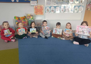 Dzieci z grupy młodszej w rzędzie trzymają swoje puzzle.